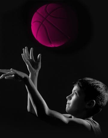 Ein junge mit einem pinken Basketball in der Hand vom Probaskets.